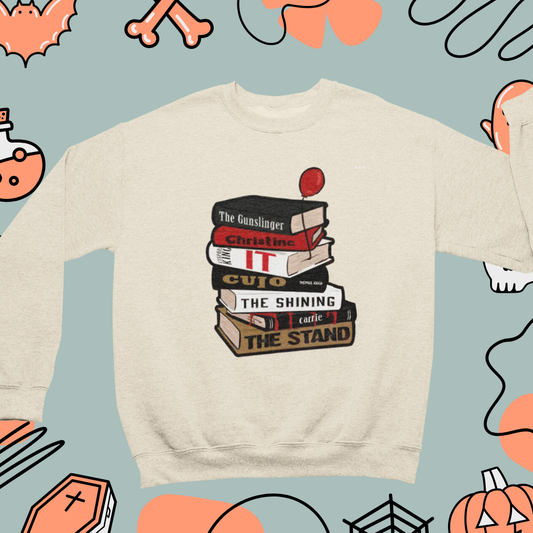 a white sweatshirt with a stack of books on it