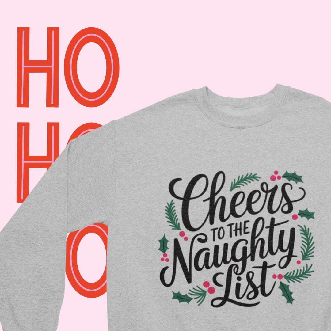 Close-up of the 'Cheers to the Naughty List' text on a cozy crewneck sweatshirt."