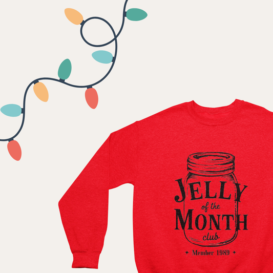 Close-up of the 'Jelly of the Month Club' text on a cozy crewneck sweatshirt."