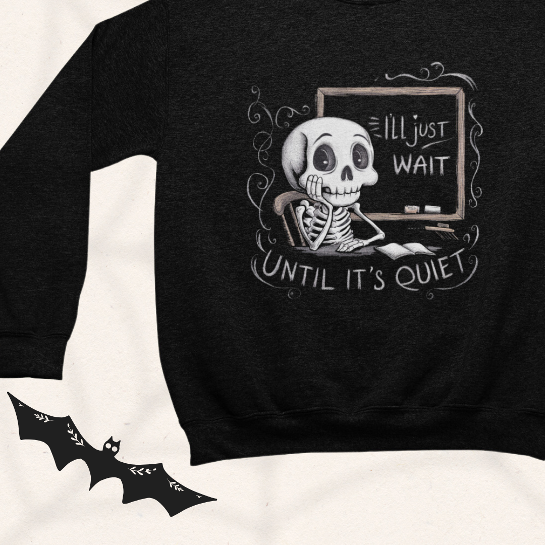 a black sweatshirt with a skeleton sitting in front of a chalkboard