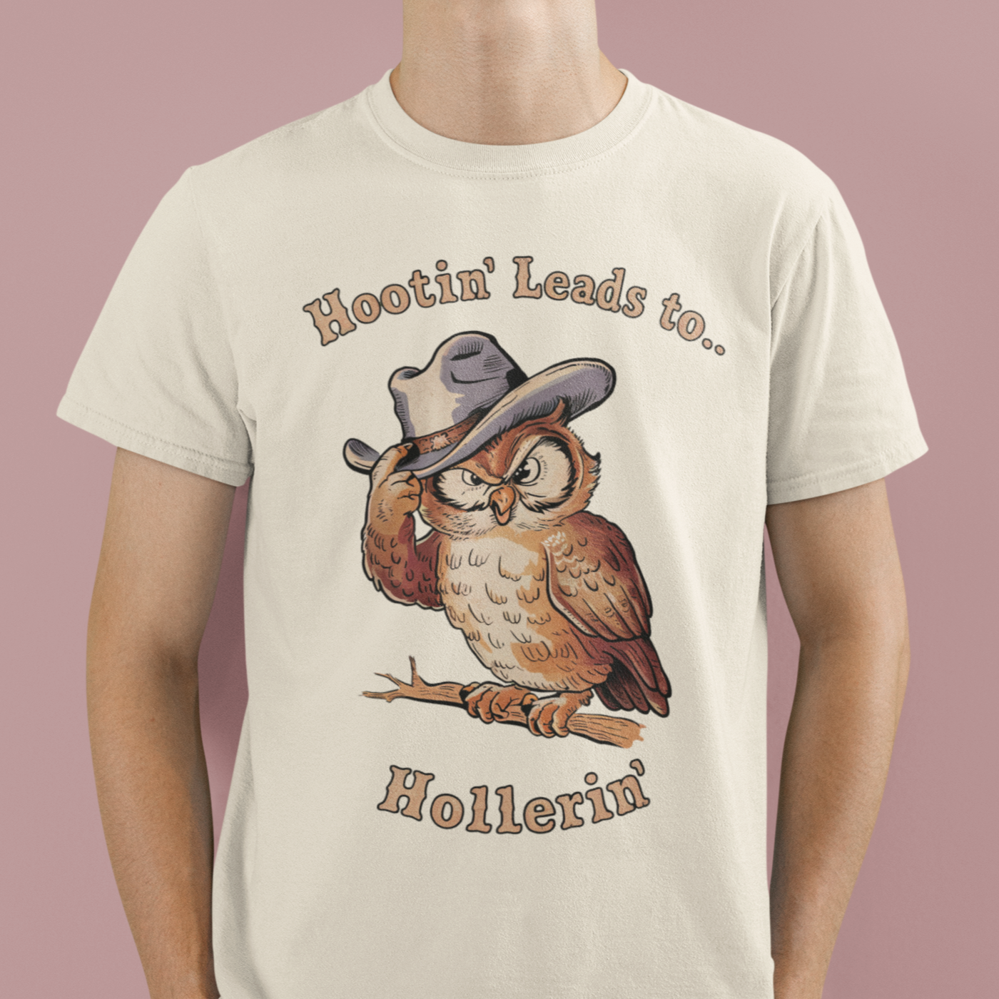 "A whimsical owl graphic tee with the text 'Hootin' Leads to Hollerin'', perfect for adventurous spirits and nature lovers."