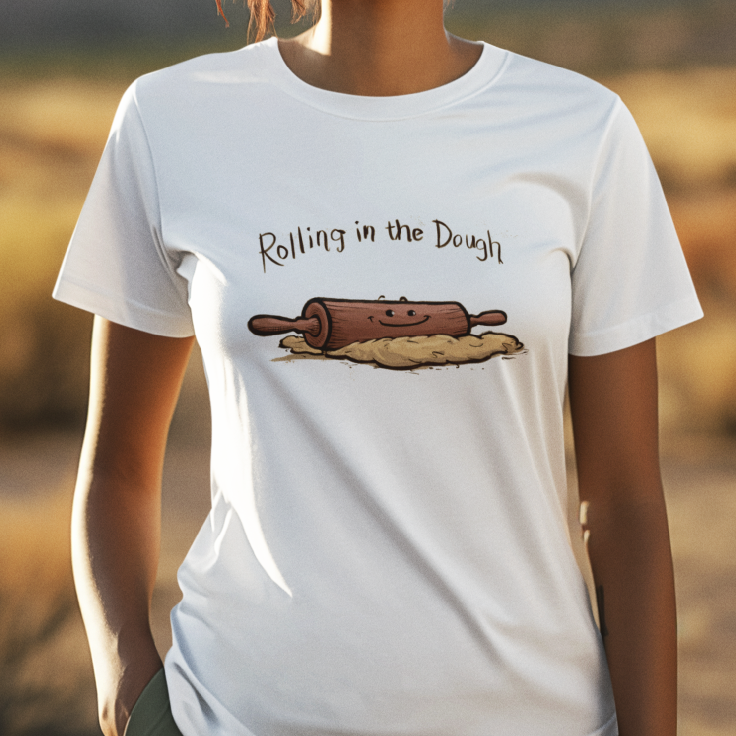 Graphic t-shirt with rolling pin and flour sack design, featuring pun 'Rolling in the Dough